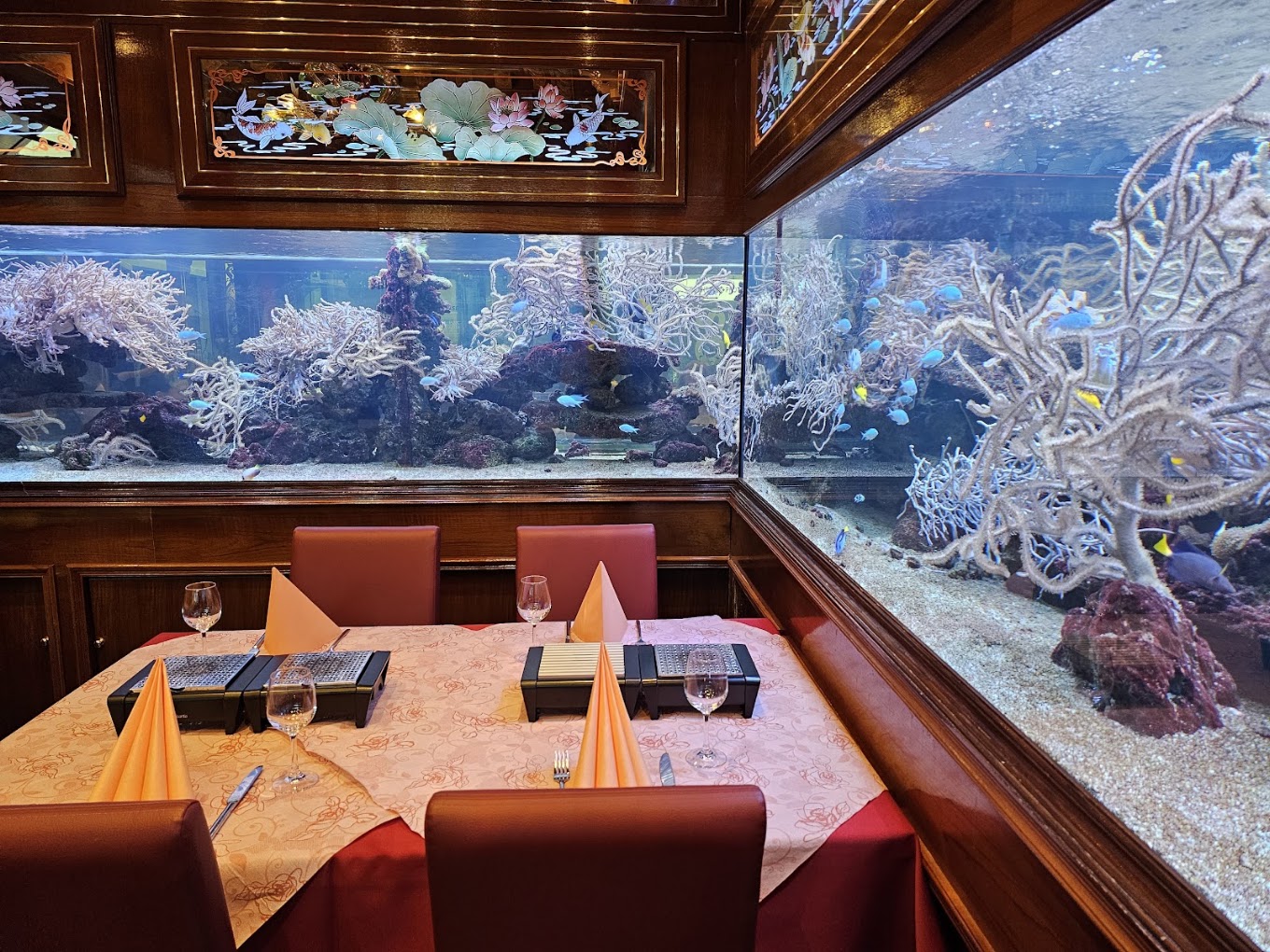 Grosses Meerwasseraquarium mit Korallen und Fischen neben einem gedeckten Tisch im Shanghai 3