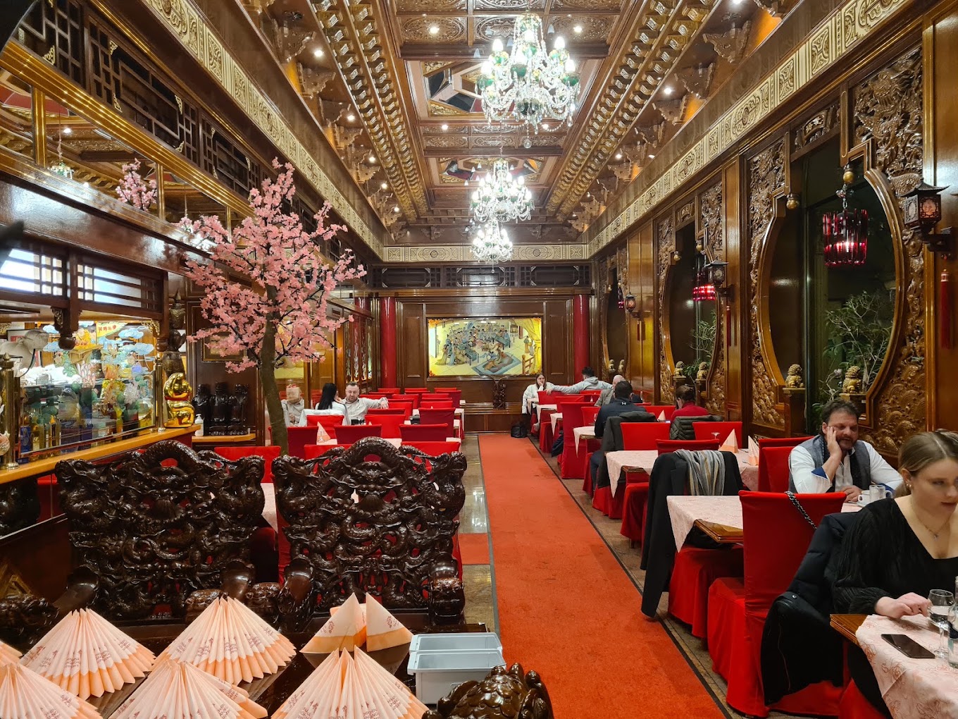 Grosser Speisesaal des Shanghai 3 mit kunstvoller Holzdecke, Kronleuchtern und Kirschblütenbaum