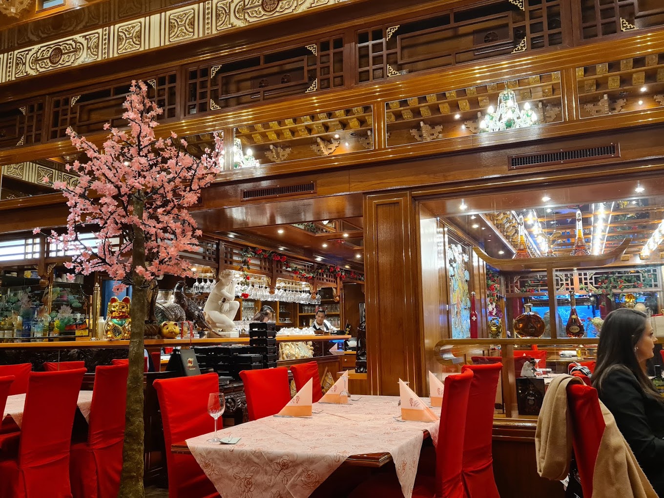 Zweiter Speisesaal des Shanghai 3 mit Kirschblütenbaum, Bar und roten Sitzmöbeln